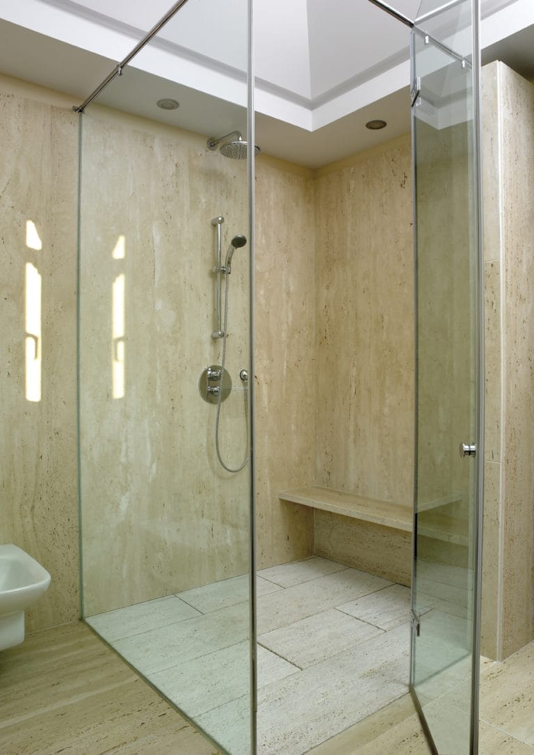 Travertine shower with clear frameless glass enclosure
